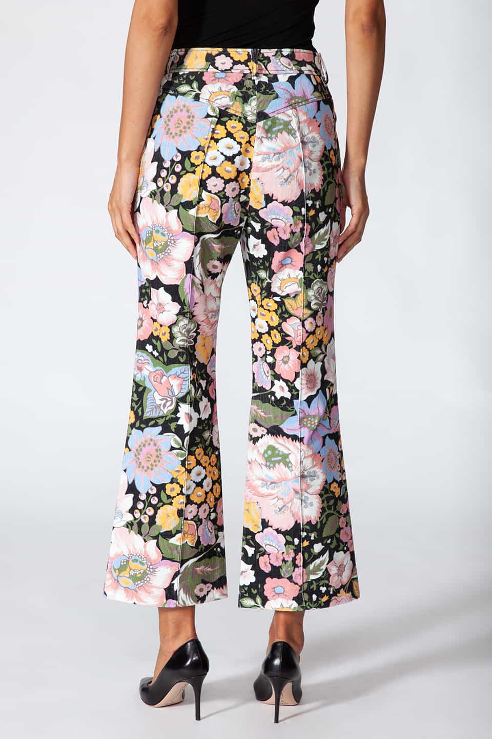Model showing Manoush European stylist's flare trousers in corduroy with floral print, posing from behind