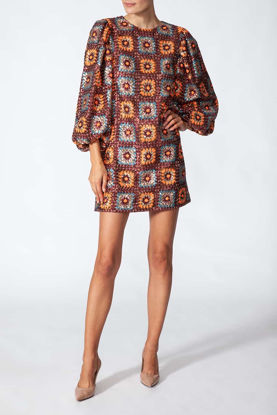 Woman posing in natural way, wearing short sequined dress in sequin crochet with long puffy sleeves in brown color. Dress from Manoush European Fashion Stylist collection.