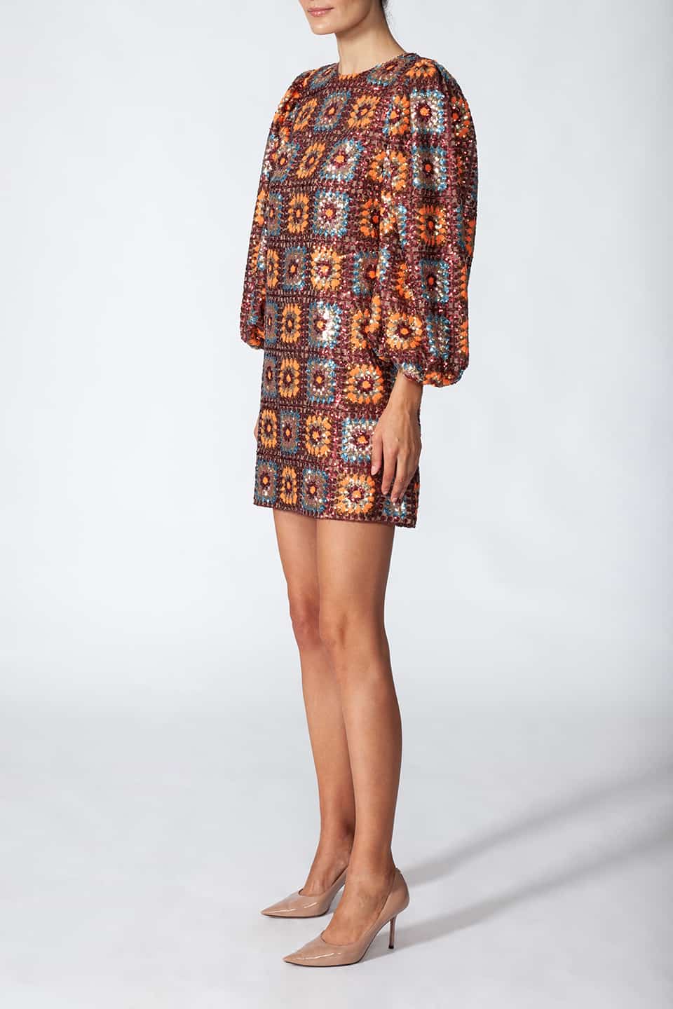 Woman in pose from right side, wearing short sequined dress in sequin crochet with long puffy sleeves in brown color. Dress from Manoush European Fashion Stylist collection.
