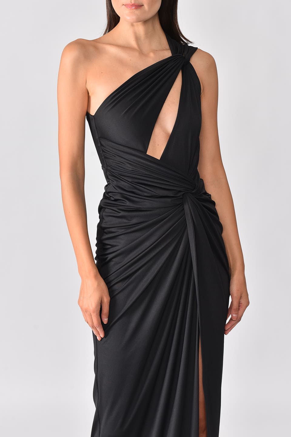 Model wearing black one shoulder dress with long side slit from Hamel fashion designer, in pose