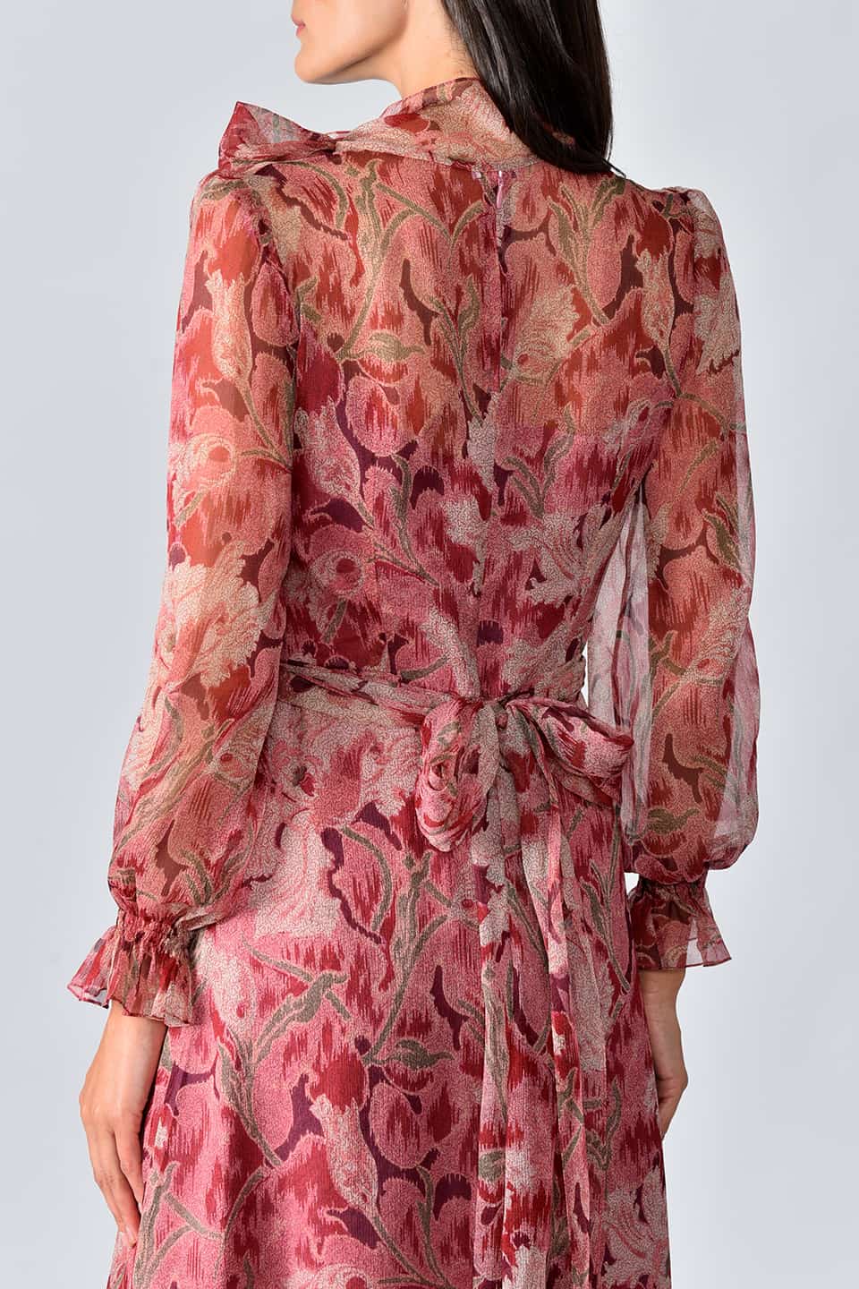 Model wearing floral print silk chiffon long dress in a burgundy garden print from stylist Vilshenko, showing back details
