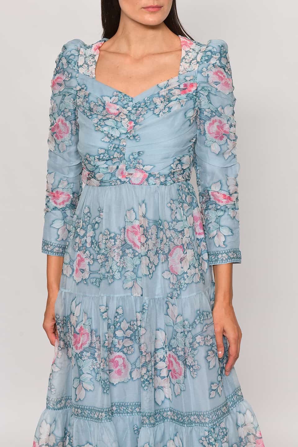 Model wearing floral print silk chiffon tiered long dress in a pale blue color from stylist Vilshenho, front details