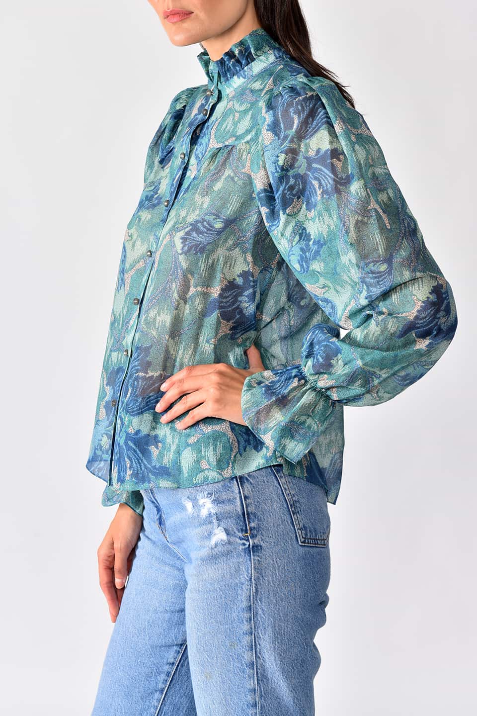 Woman wears silk cotton blouse with long sleeves in a forest green print from stylist Vilshenko, in a natural pose